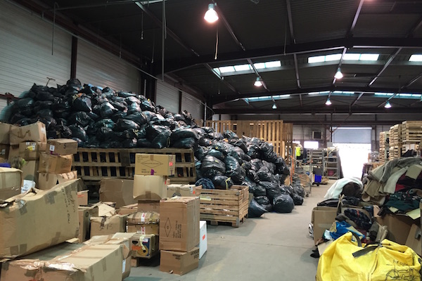 Pile of garbage bags filled with insulation material at Help Refugees L’Auberge des Migrants Warehouse