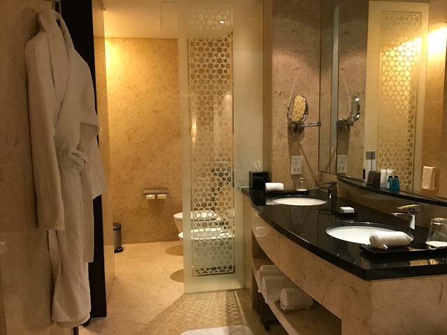 Hilton Dubai Hotel Bathroom with Double Sink, Bidet, and Bath Robe